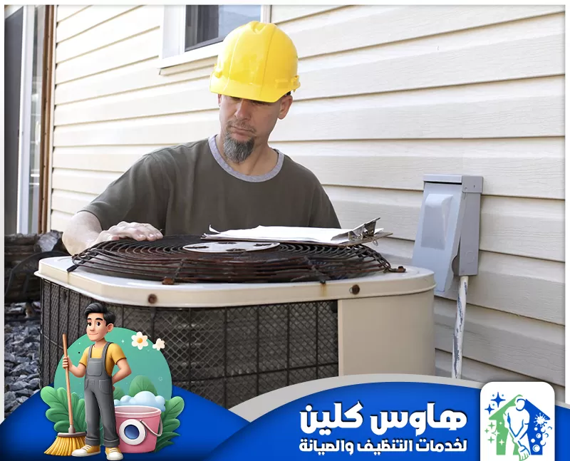 شركة تنظيف مكيفات بالدمام | 0506747660 | هاوس كلين رجل يرتدي خوذة وقميصًا أصفر يُصلح مكيف هواء، مُمثلًا شركة تنظيف في الدمام