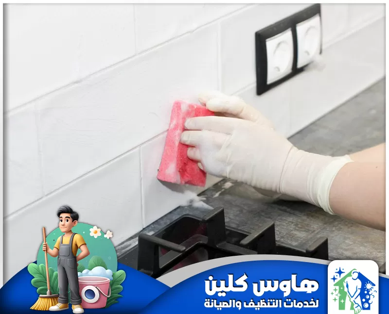شركة غسيل مطابخ بالرياض 0506747660 هاوس كلين عامل يمسك اسفنجة ويقوم بتنظيف حائط المطبخ