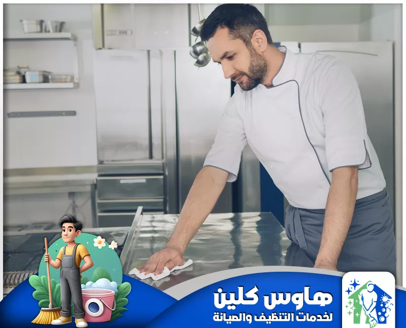 ارخص شركة تنظيف مطاعم بالرياض | 0506747660 | معتدمة رجل يُنظّف مطبخًا، مع لافتة زرقاء وبيضاء تُشير إلى خدمة تنظيف مطاعم في الرياض