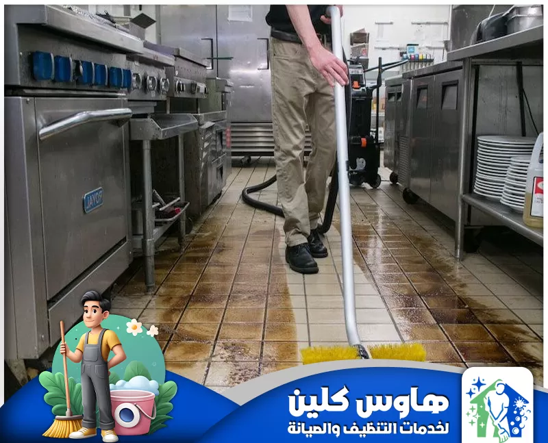شركة تنظيف مطاعم بالرياض | 0506747660 | هاوس كلين رجل ينظف مطبخا، مع لافتة زرقاء وبيضاء تُشير إلى خدمة تنظيف مطاعم في الرياض
