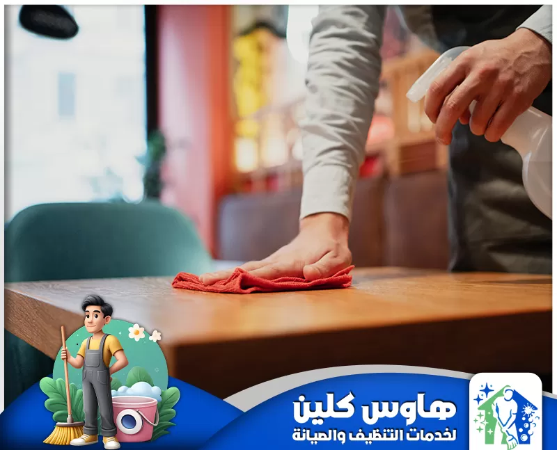 شركة تنظيف مطاعم بالرياض | 0506747660 | معتمدة رجل ينظف طاولة مطعم بعناية بقطعة قماش، لضمان بيئة طعام نظيفة.